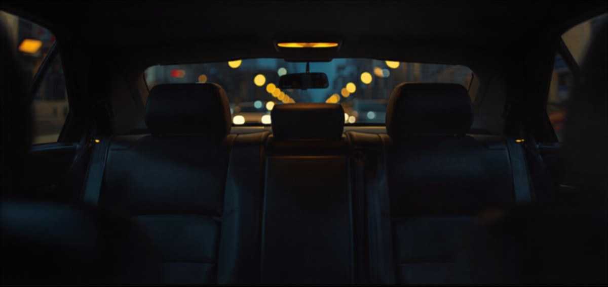 Banquette arrière soignée d’un taxi à Lille, éclairée par les lumières de la ville la nuit